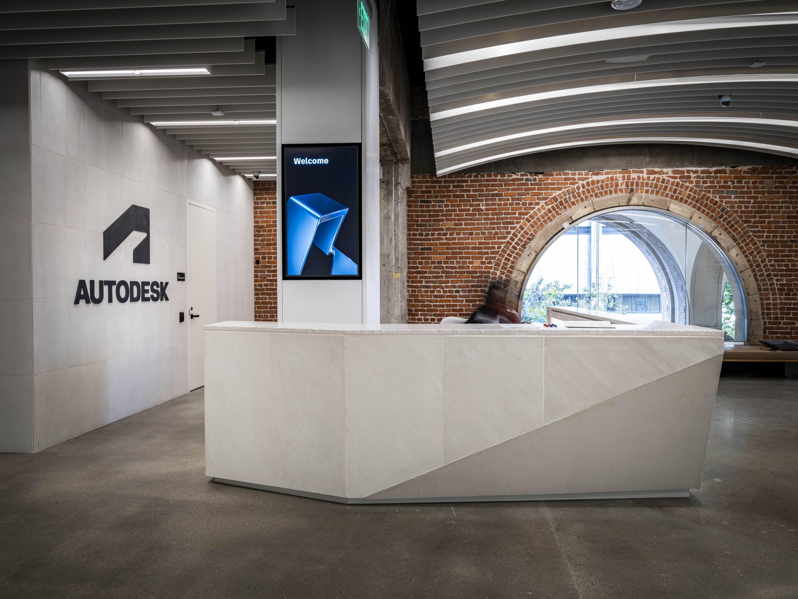 Autodesk Gallery reception desk, framed by the building's restored brick archway